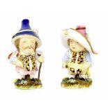 Two porcelain Mansion House dwarves in the manner of Derby, each modelled wearing a hat, upon floral