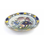 18th century Delft circular shallow dish, painted in polychrome enamels with foliate designs, 13.