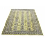 Bukhara type rug, on a green ground with three gul runs to the centre, 72" x 52" approx