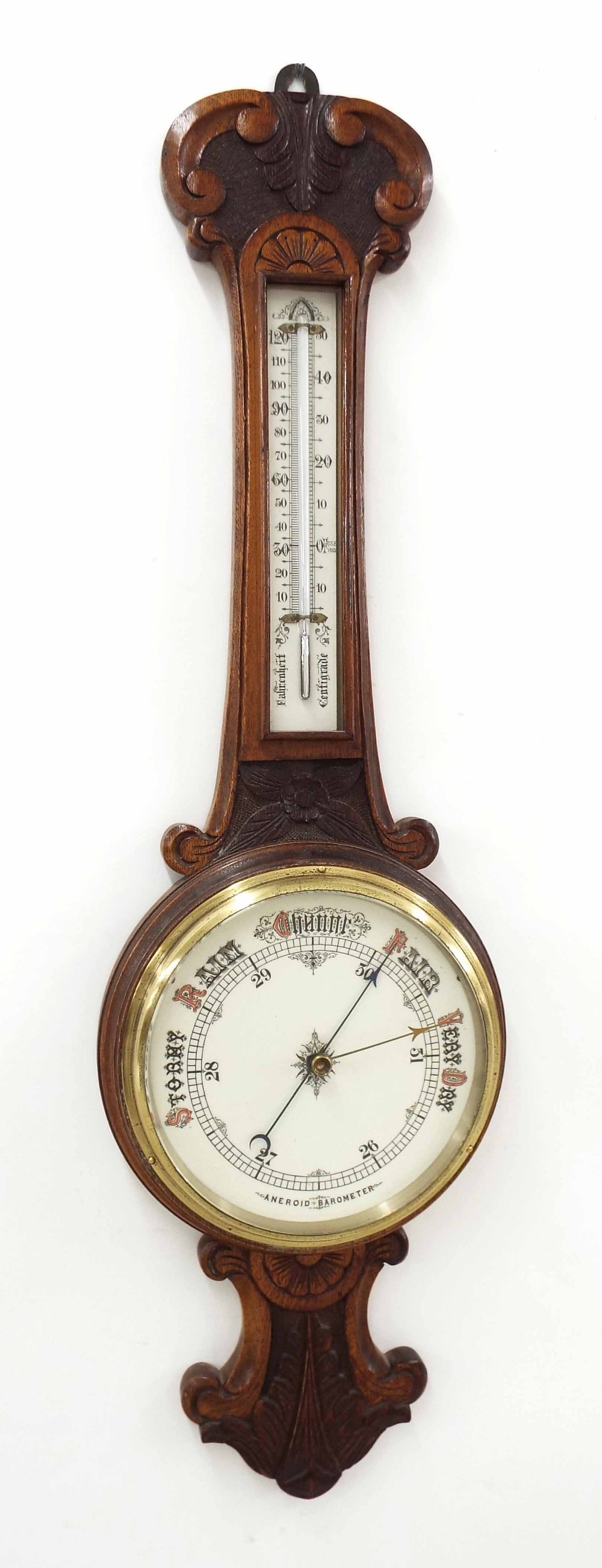 Oak aneroid barometer/thermometer within a foliate carved case