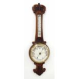 Oak aneroid barometer/thermometer within a foliate carved case