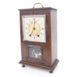 Oak cased automaton two train mantel clock striking on a bell, the 4.25" square silvered dial fitted