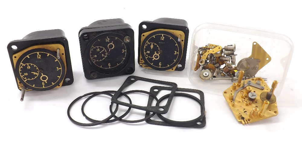 Three 8 day aircraft clocks for repair or spares; together with a selection of aircraft clock parts