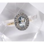 18ct oval aquamarine and diamond cluster ring, the aquamarine 1.50ct approx in a round brilliant-cut