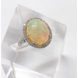 18ct white gold opal and diamond oval set ring, the cabouchon opal 14mm x 13mm in a diamond