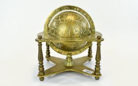 A Vintage Solid Brass Globe Decorative globe with zodiac engraved equator ring and x frame base.