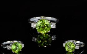 A Silver Peridot And White Topaz Dress Ring Set with solitaire Peridot of good colour,