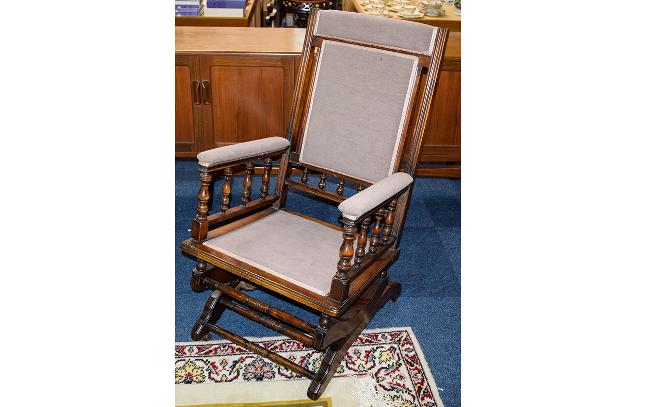 Antique Rocking Chair Of Plain form with spindle arm rests, upholstered in dove grey chenille.