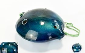 A Ceramic Ocarina Handheld spherical flute instrument in glazed blue ceramic,