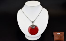 A Red Coral Disc Pendant With Silver Chain Long silver box chain with attached circular pendant and