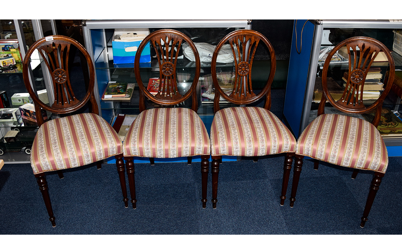 Four Round Back Dining Chairs In dark wood with oval back and carved floral detail to centre.