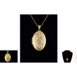 A 9ct Gold - Hinged Oval Shaped Dragon Charm Locket with Attached 9ct Gold Chain.