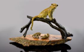 A Good Quality Sculpture of a Cold Painted on Metal Figure of a Cheetah Perched on a Large Fallen