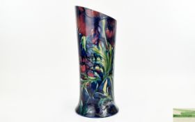Moorcroft Tubelined Anemone Vase Trumpet form vase on blue ground with purple anemone pattern.