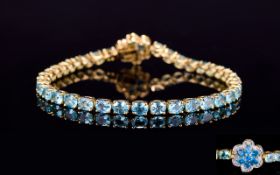 Paraibe Apatite and Neon Apatite Floral Clasp Tennis Bracelet, a row of oval cut paraibe apatite,