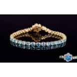 Paraibe Apatite and Neon Apatite Floral Clasp Tennis Bracelet, a row of oval cut paraibe apatite,