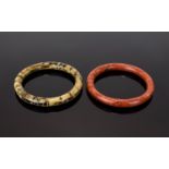 A Pair Of Vintage Agate Bangles Two in total, the first in brick red tone with striated detail.