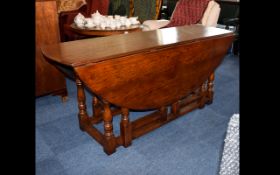 A Large Oak Drop Leaf Table Oak cottage style table with aged patina and gateleg supports.