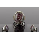 Russian Eudialyte Ring, a 12ct oval cut solitaire eudialyte, bezel set in a silver mount, showing