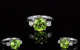 A Silver Peridot And White Topaz Dress Ring Set with solitaire Peridot of good colour, the shoulders