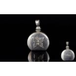 A Mexican Silver Decorative Perfume/Attar Pendant A small silver circular flask with flat base and