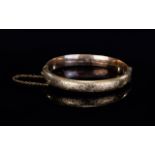 Antique Period 9ct Gold Hinged Bangle with Safety Chain & Chased Floral Decoration. Marked 9ct.