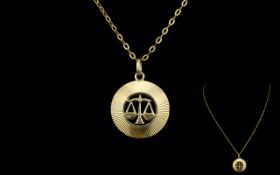 Gold Pendant And Chain A circular pendant with central reticulated detail in the form of a pair of