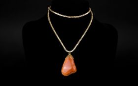 A Polished Stone Mounted on a Gold Colour Chain.