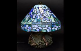 Tiffany Style Table Lamp with squat heavy solid base surmounted by dolphin figures.