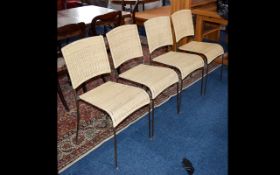 A Set of Four Light Wicker Chairs with black metal legs.