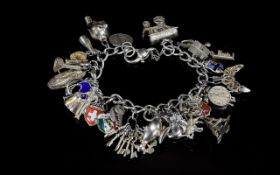 A Silver Curb Good Quality Bracelet Loaded with 30 Silver Charms of Interest.