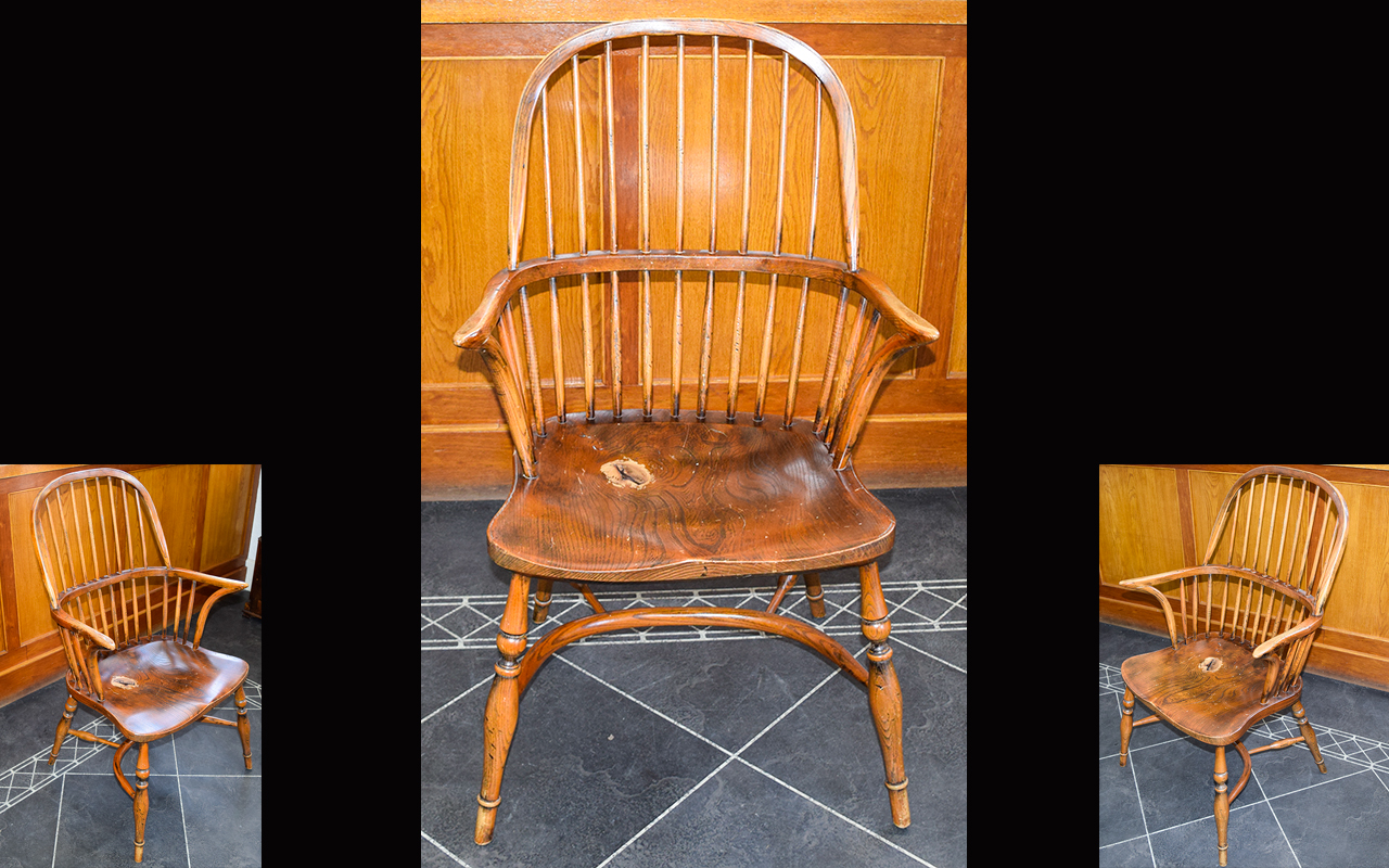 A Yew And Elm wood Windsor Armchair With Dished Seat. Circa 19th Century. Bow shaped strectchers.