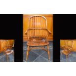 A Yew And Elm wood Windsor Armchair With Dished Seat. Circa 19th Century. Bow shaped strectchers.