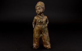 Early 20th Century Cast Metal Figure In the form of a young boy in 19th century dress. Aged