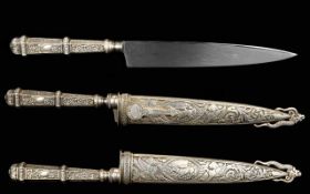 A Decorative Gaucho Boot Knife By Inox Silver tone reproduction knife with highly ornamented handle