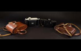 Two Vintage Cameras To include one Kodak, each housed in original brown leather carry cases. Good