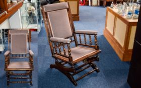 Antique Rocking Chair Of Plain form with spindle arm rests, upholstered in dove grey chenille.