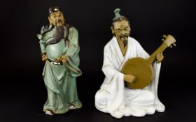A Pair Of Oriental Figures The first fashioned in resin in the form of a seated Mandolin player