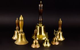 Collection of 7 Brass Bells, various sizes, the largest measuring 12 inches with an oak handle.