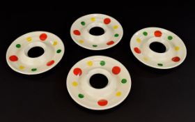 Four round egg cups early Midwinter decorated in coloured spots.