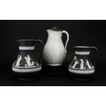 Black and White Wedgwood Jugs (2) in total. Decorated to body with classical garden scenes.
