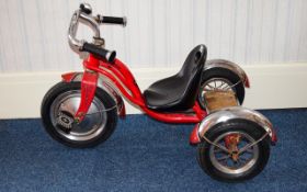 A Child's Schwinn Tricycle painted in red with chrome finish.