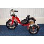A Child's Schwinn Tricycle painted in red with chrome finish.