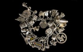 A Vintage Silver Curb Bracelet Loaded with 28 Silver Charms.