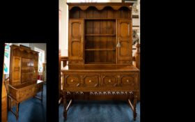 Golden Oak Dresser And Rack Comprising central shelves between two cupboards and two short drawers.