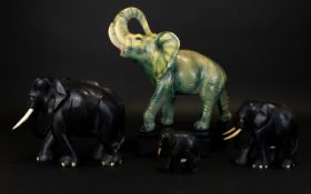 A Collection Of Elephant Figurines Four in total to include descending size carved ebonised wood