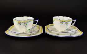 A Pair Of Shelley Art Deco Queen Anne Trios Two in total each comprising charger, saucer and cup,