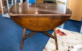 Dark Wood Drop Leaf Dining Table Of plain form with x-frame bottom stretcher.