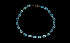 A 9ct Blue Topaz Tennis Bracelet Attractive bracelet set in 9ct yellow gold with 22 faceted oval