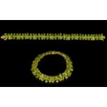 Peridot Floral Line Bracelet, 41cts of pear cut peridot set as stylised flowers in a single row,